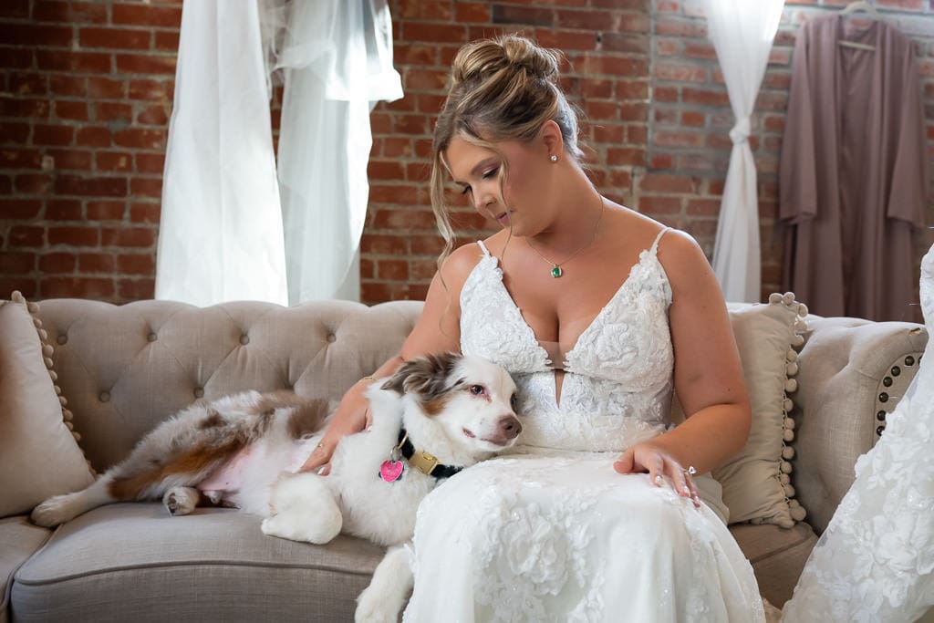 Bride relaxing before the ceremony while petting her dog in the bright getting-ready room at Union Kansas City
