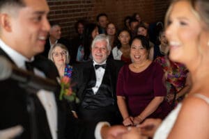 Happy parents smiling during a multicultural wedding ceremony at Union Kansas City, with the couple blurred in the foreground