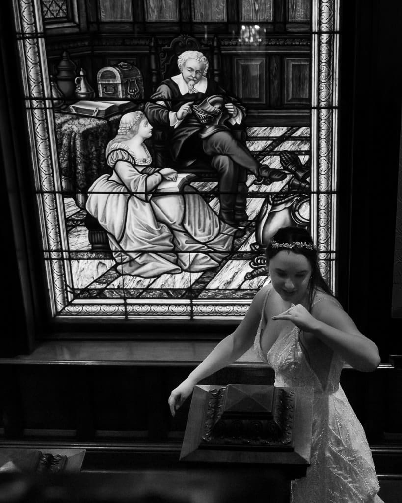 Bride walking in front of the stained glass on Wyeth-Tootle Mansion’s staircase