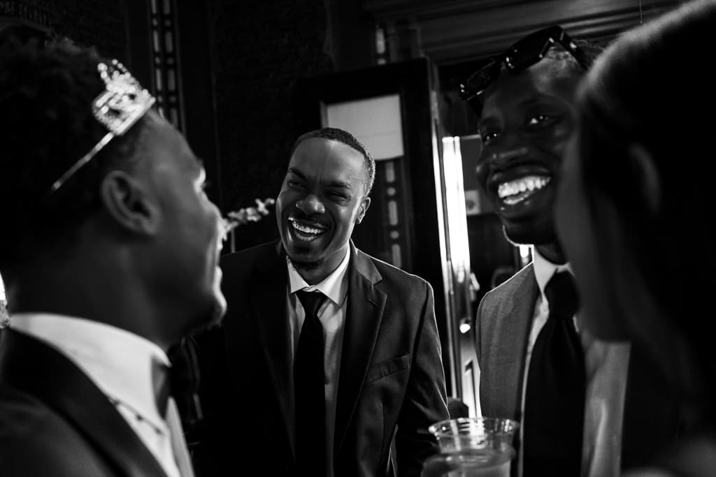 Guests and groom laughing at his French-inspired wedding at Wyeth-Tootle Mansion in St. Joseph, Missouri