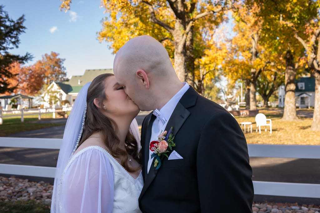 Wedding Couple kissing at Lone Summit Ranch fall leaves color