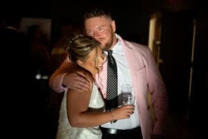 Guest hugging the bride during, with dramatic light in the Union speakeasy