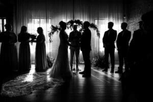 Couple and bridal party silhouetted against the white windows of Union KC