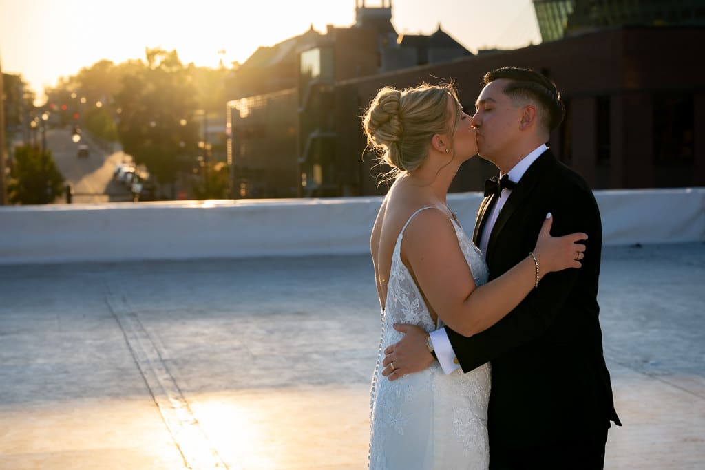 Multicultural couple kissing on the rooftop of Union Kansas City during golden hour