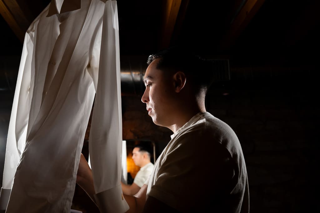 Groom next to his white shirt getting ready for his Vietnamese multicultural wedding at Union Kansas City
