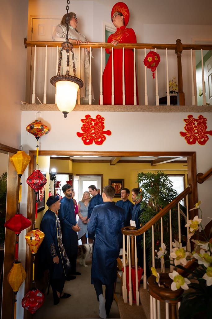 Bride waiting upstairs with her mom while groomsmen gather downstairs
