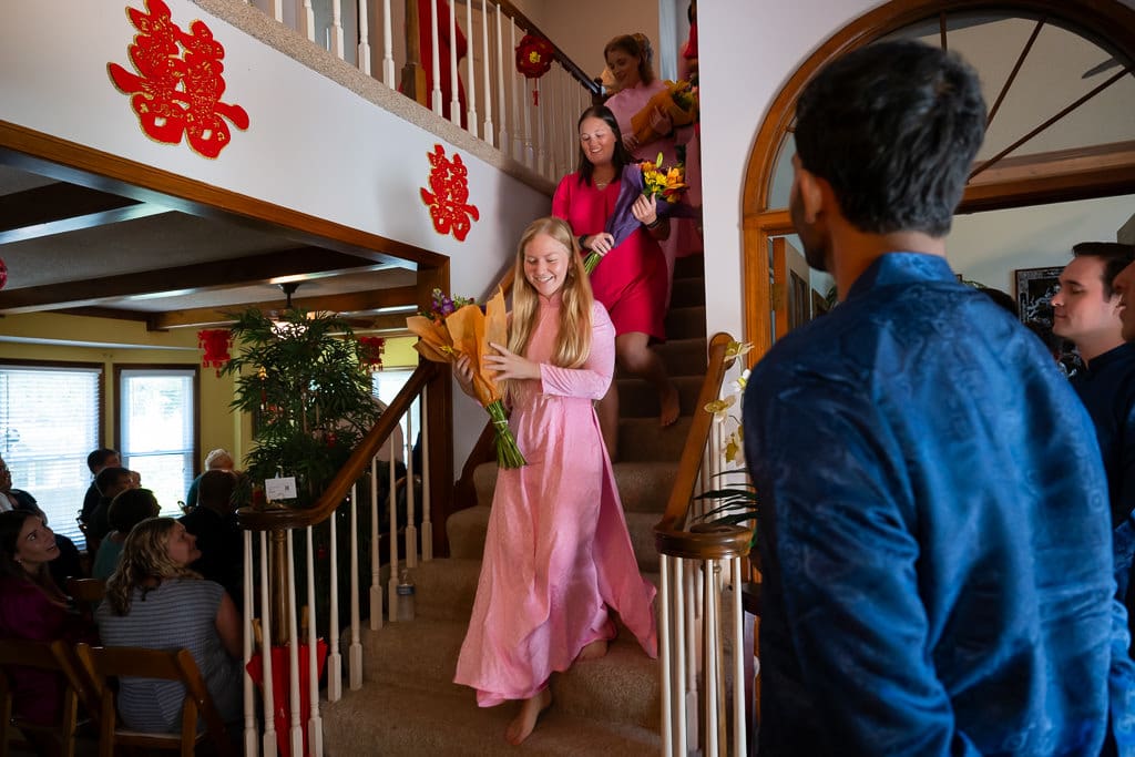 Bridesmaids walking down the stairs with flowers