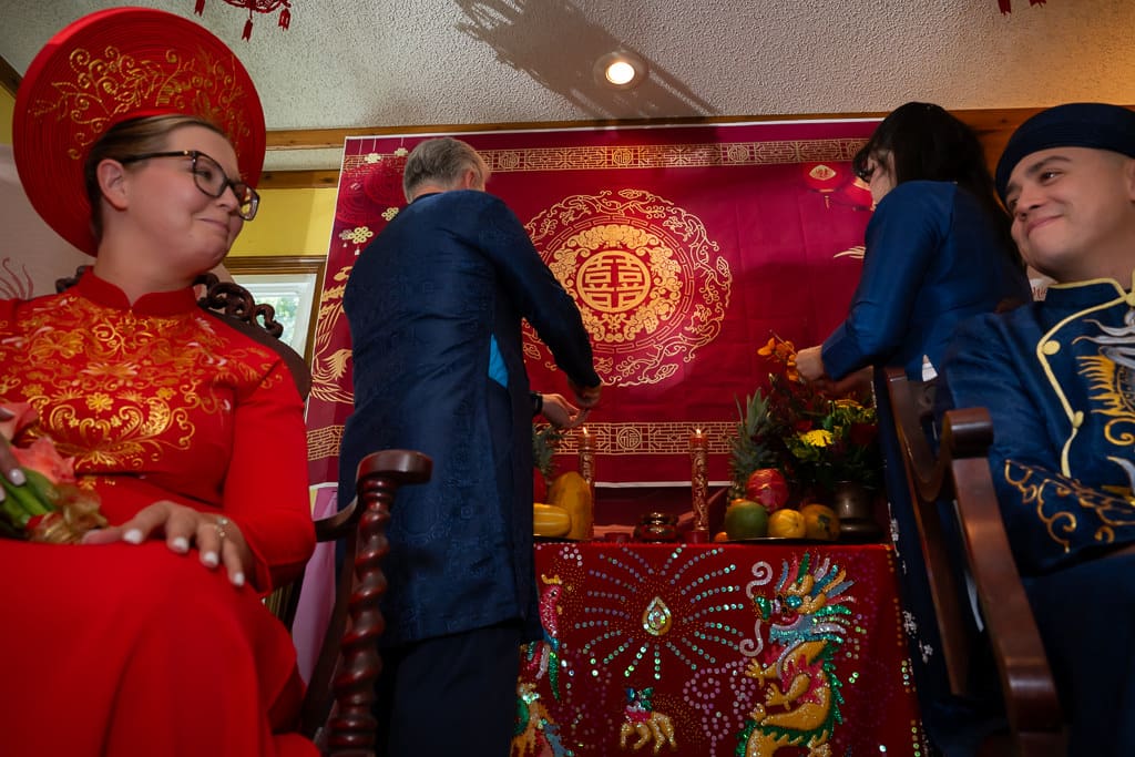 parents burning incense and couple smiling during Vietnamese tea ceremony