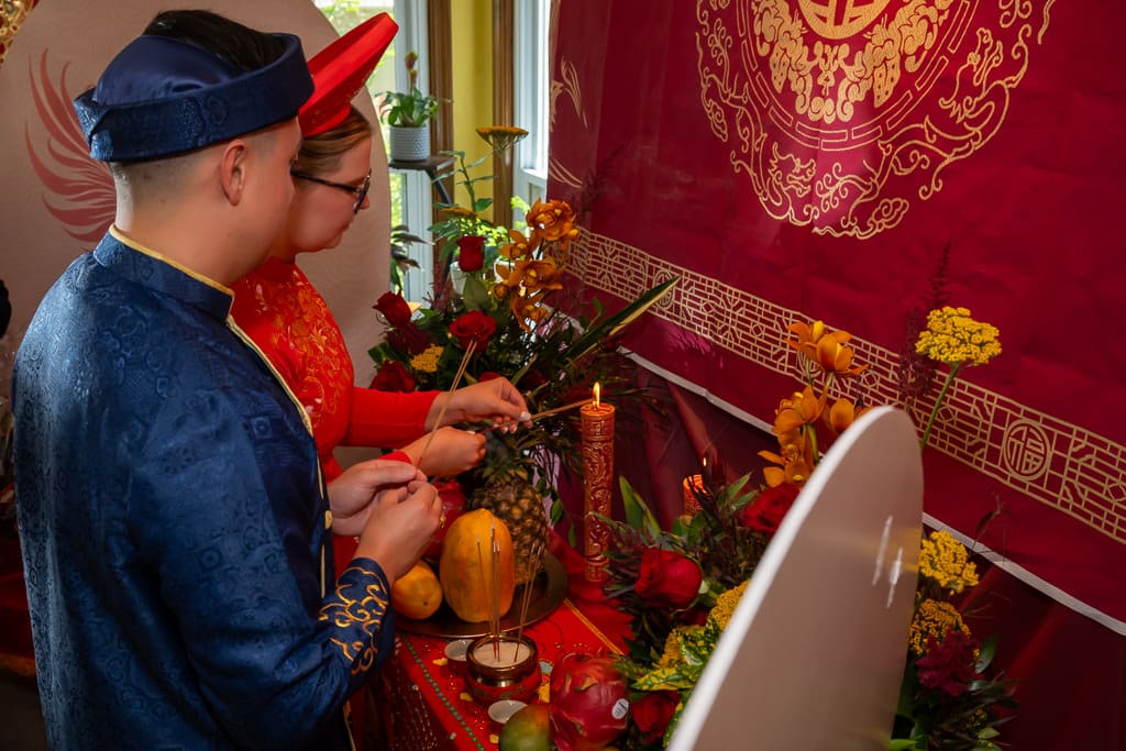 Couple burning incense during Vietnamese tea ceremony