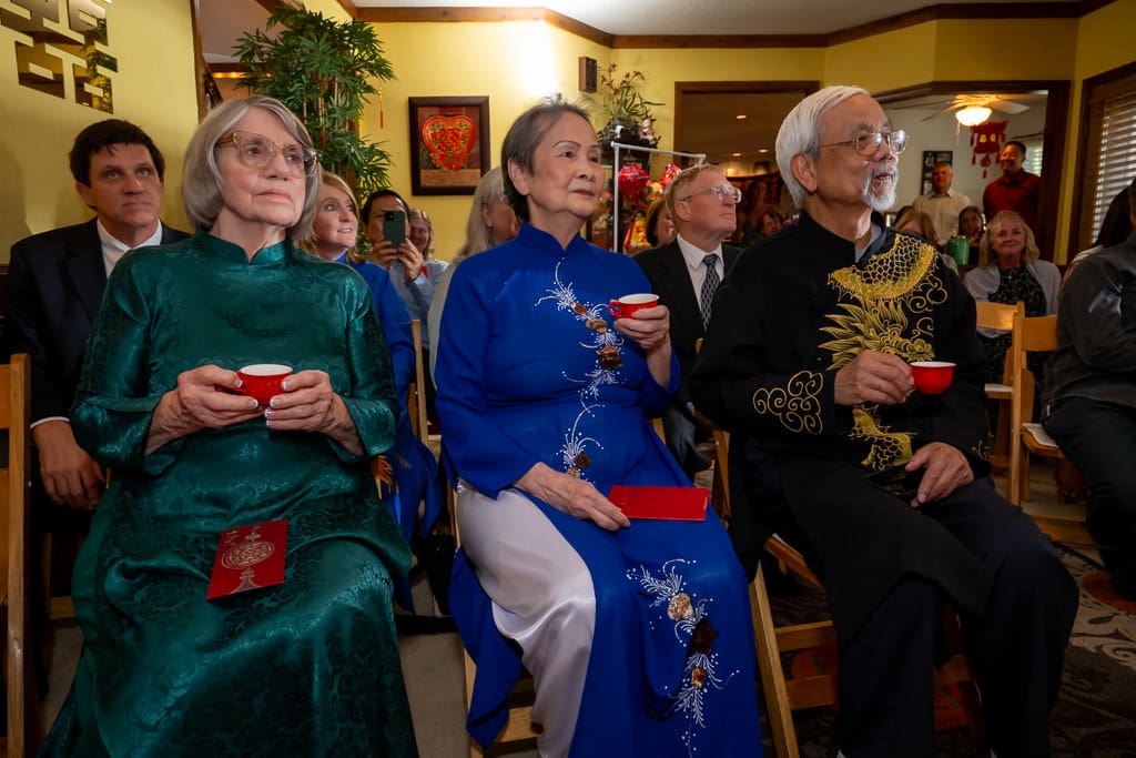 The elder with tea red cups in traditional outfit during Vietnamese tea ceremony