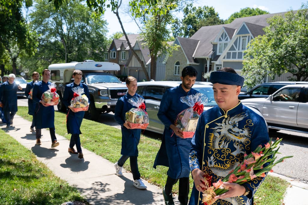 Groomsmen walking with gifts during Vietnamese tea ceremony