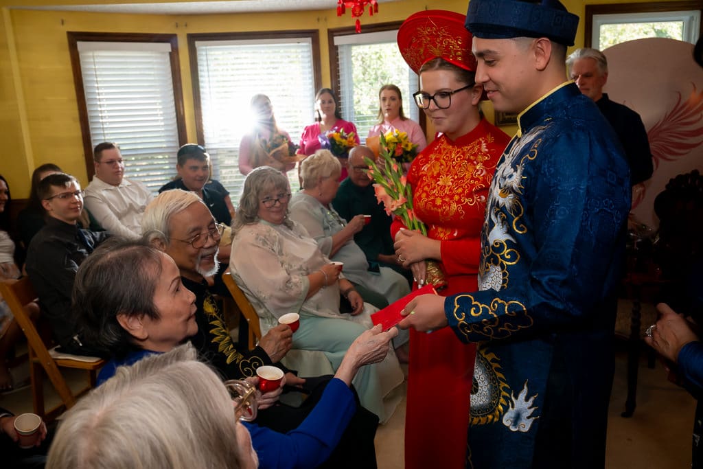 Vietnamese tea ceremony, grand parent giving a red envelope to the couple