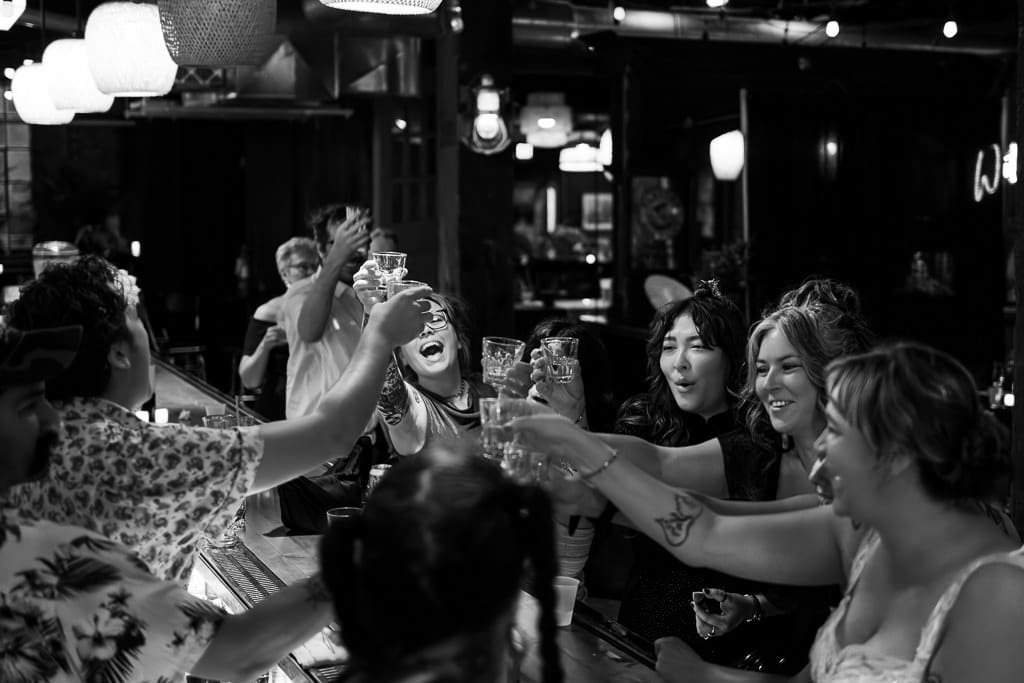 Black and white photo of guests raising their glasses for a cheers at The Ship in the West Bottoms