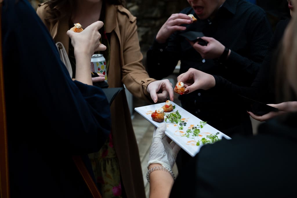 Guests reaching for amuse bouche appetizers during cocktail hour at an intimate wedding in Kansas City