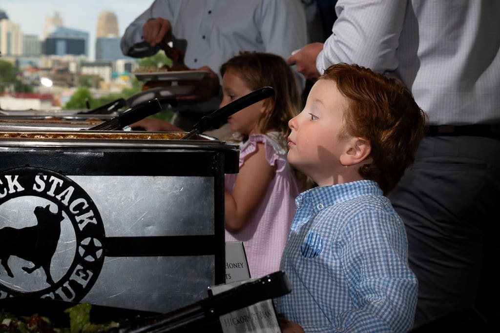 Children watching Jack Stack Barbecue being served with the Kansas City skyline in the background at a Boulevard Brewing Company wedding