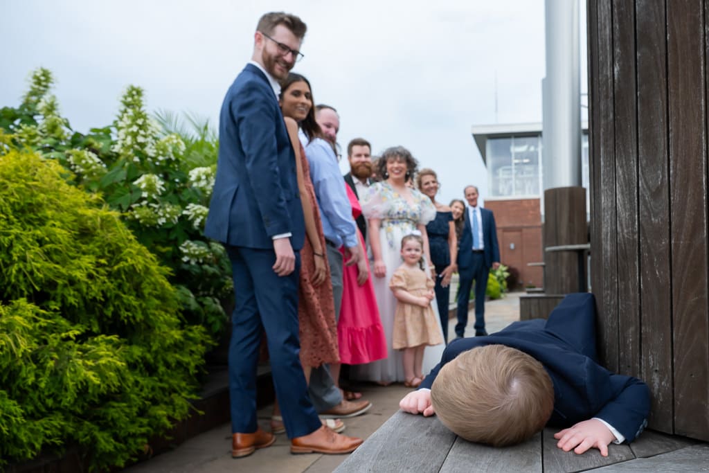 Family photo on the terrace as a little boy lies down on the ground at a Boulevard Brewing Company wedding