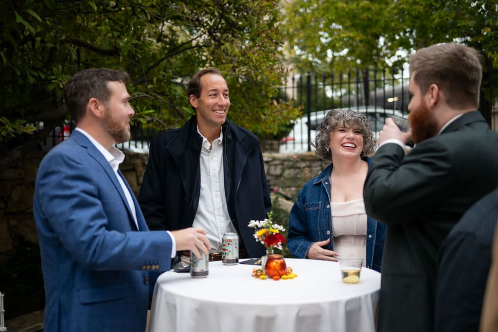 Bride and groom chatting with guests during cocktail hour on the patio at Southmoreland on the Plaza