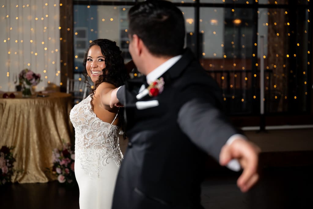Groom spinning toward the bride as she beams during their first dance at The Stanley in Lee's Summit