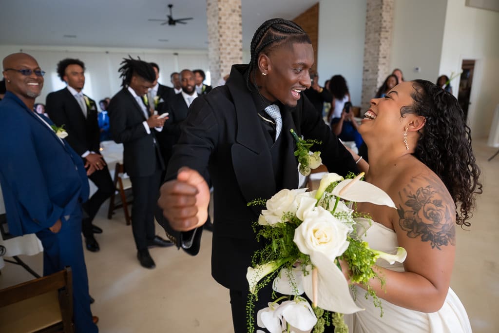 Bride and groom dancing into the reception for their grand entrance as groomsmen cheer behind them