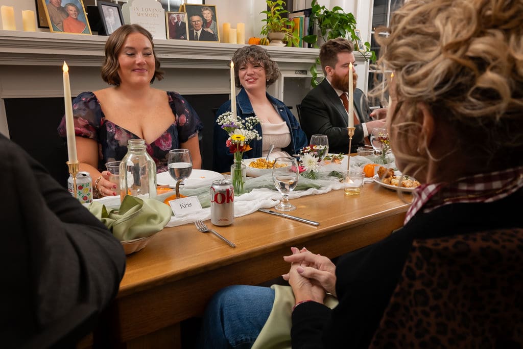 Guests smiling at the candlelit dinner table during the reception