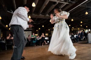 Father of the bride in a Blues Brothers hat and sunglasses dancing with the bride during the father daughter dance
