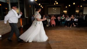 Father and bride dancing across the floor during a Blues Brothers themed father daughter dance at Boulevard Brewing Company