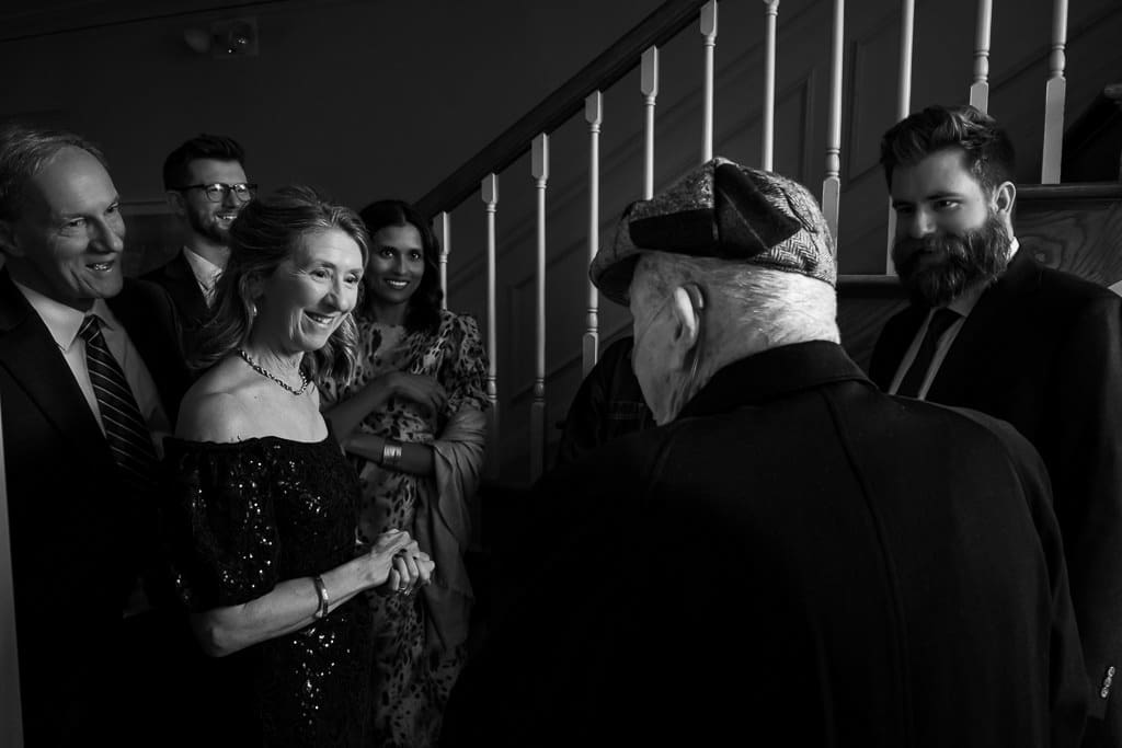 Black and white photo of a grandfather greeting family after the reception