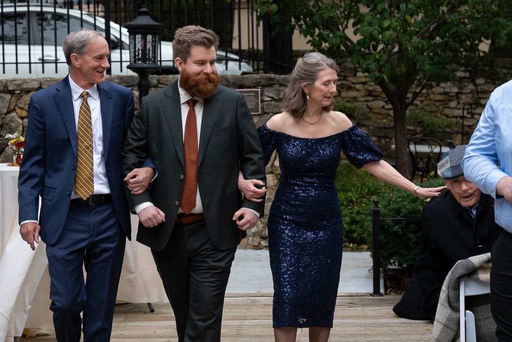 Groom walking down the aisle arm in arm with his parents at Southmoreland on the Plaza