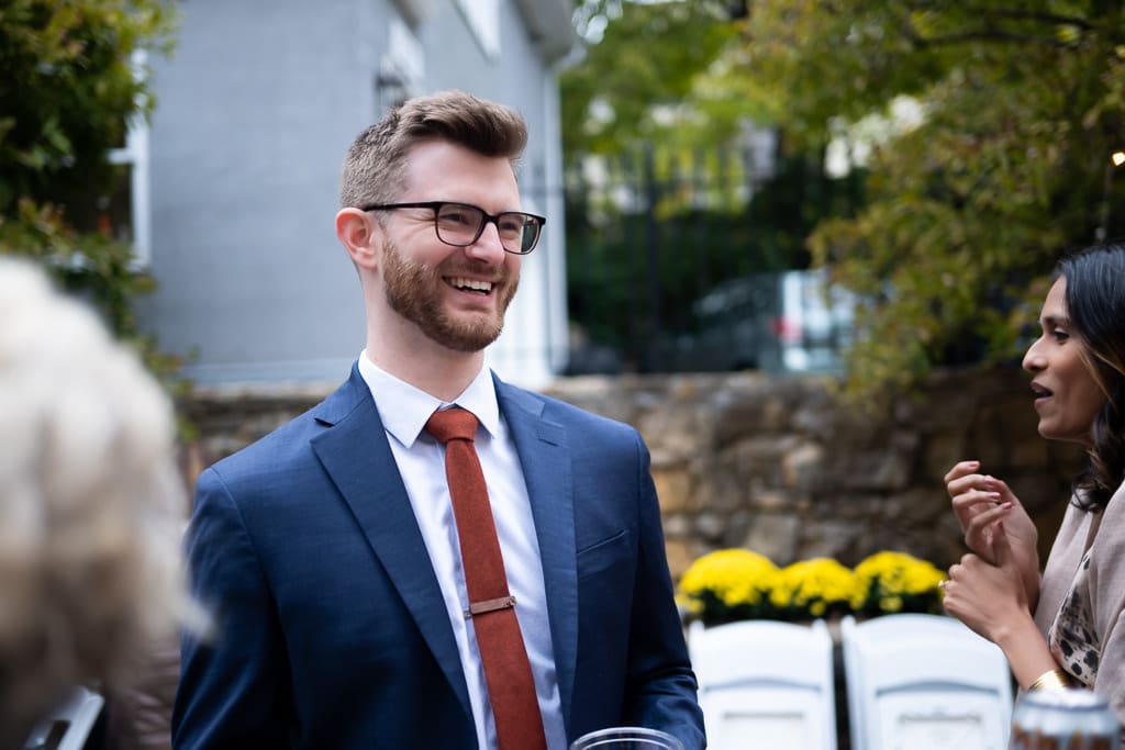 Guest in a blue suit laughing during cocktail hour