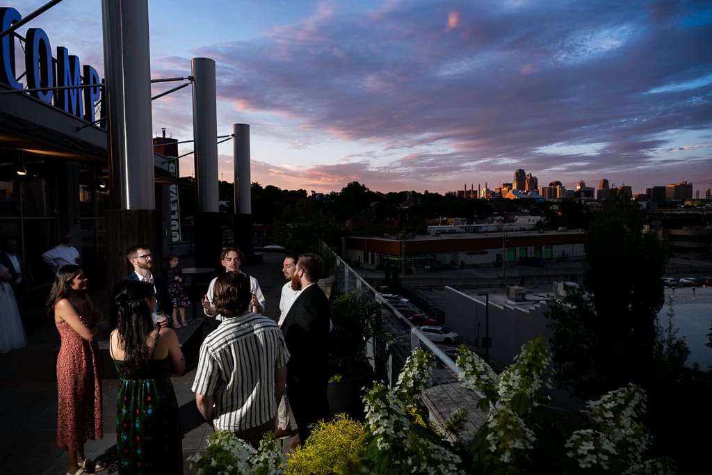 Wedding guests on the terrace at sunset with a skyline view of Kansas City at Boulevard Brewing Company