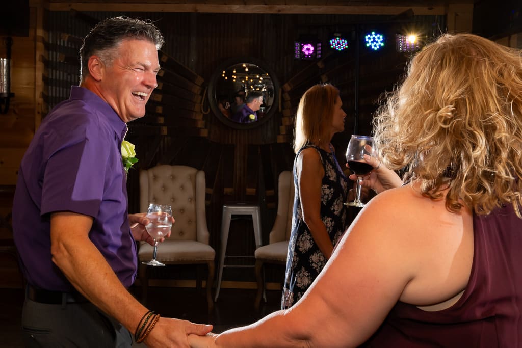 Guest laughing with a friend at the wedding reception after a lesbian wedding in Kansas