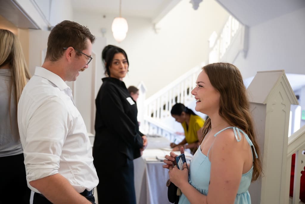 Wedding vendors chatting at the check in table at the foot of the white staircase at Melrose Abbey