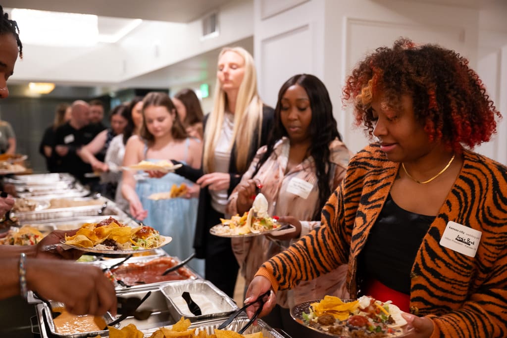 Wedding vendors filling their plates along the buffet line at a networking event at Melrose Abbey