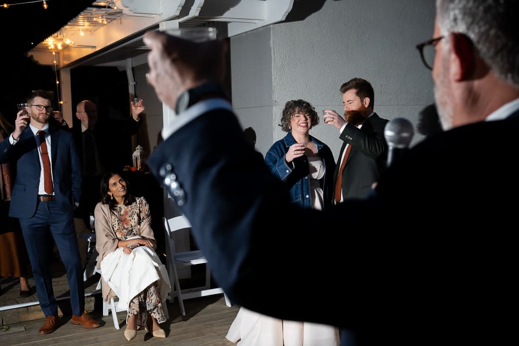 Guests raising their glasses during a toast at the wedding reception