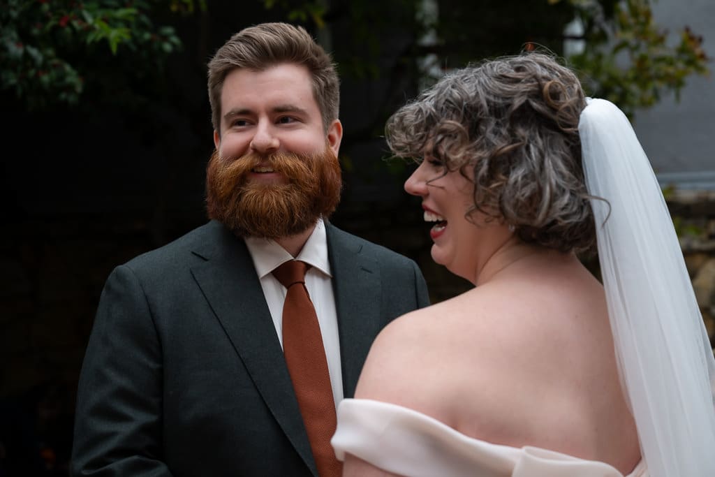 Groom smiling at the bride during their outdoor wedding ceremony at Southmoreland on the Plaza in Kansas City