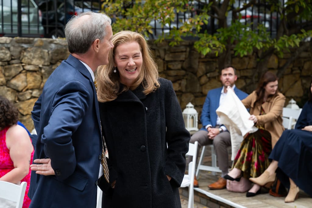 Guests laughing during the outdoor wedding ceremony in the garden at Southmoreland on the Plaza