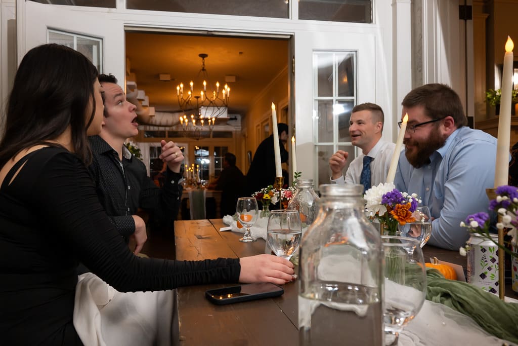 Guests laughing around the dinner table at an intimate wedding reception at Southmoreland on the Plaza in Kansas City