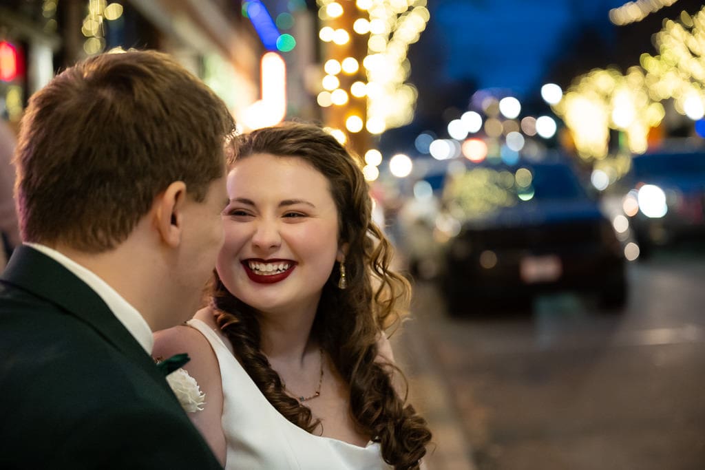Tamieka smiles close to Drake on a downtown Lee's Summit street glowing with Christmas lights
