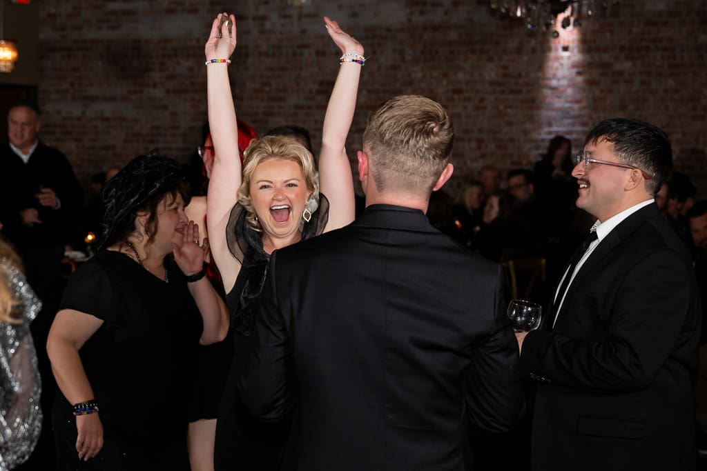 A guest throws her arms up and cheers on the dance floor at The Stanley