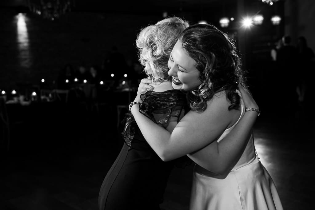 Black and white photo of Tamieka hugging her maid of honor tightly on the dance floor