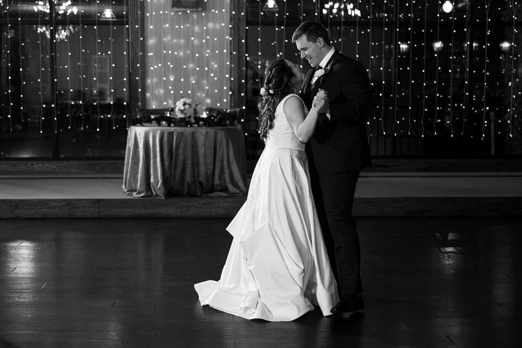 Black and white photo of Drake and Tamieka slow dancing in front of a wall of string lights at The Stanley